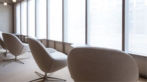 A modern conference room with large windows, minimalist chairs, and hanging pendant lights. - The Hotels Hakata Kasane Bayside (Fukuoka)