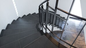 A modern staircase with dark tiles and metal railings, leading to a higher floor. - The Hotels Hakata Kasane Bayside (Fukuoka)