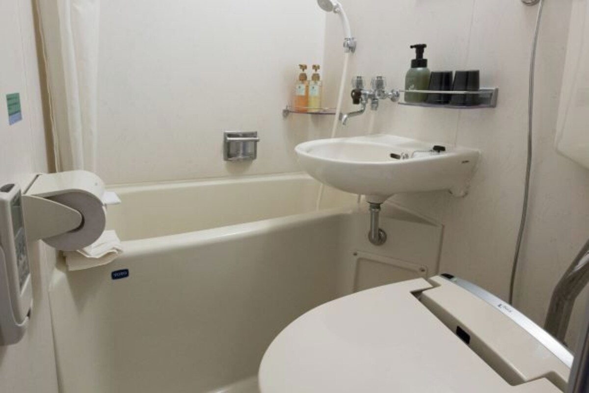 Een badkamer met toilet, wastafel en bad.