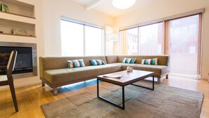 Una sala de estar moderna con un sofá modular, una mesa de centro y una chimenea.