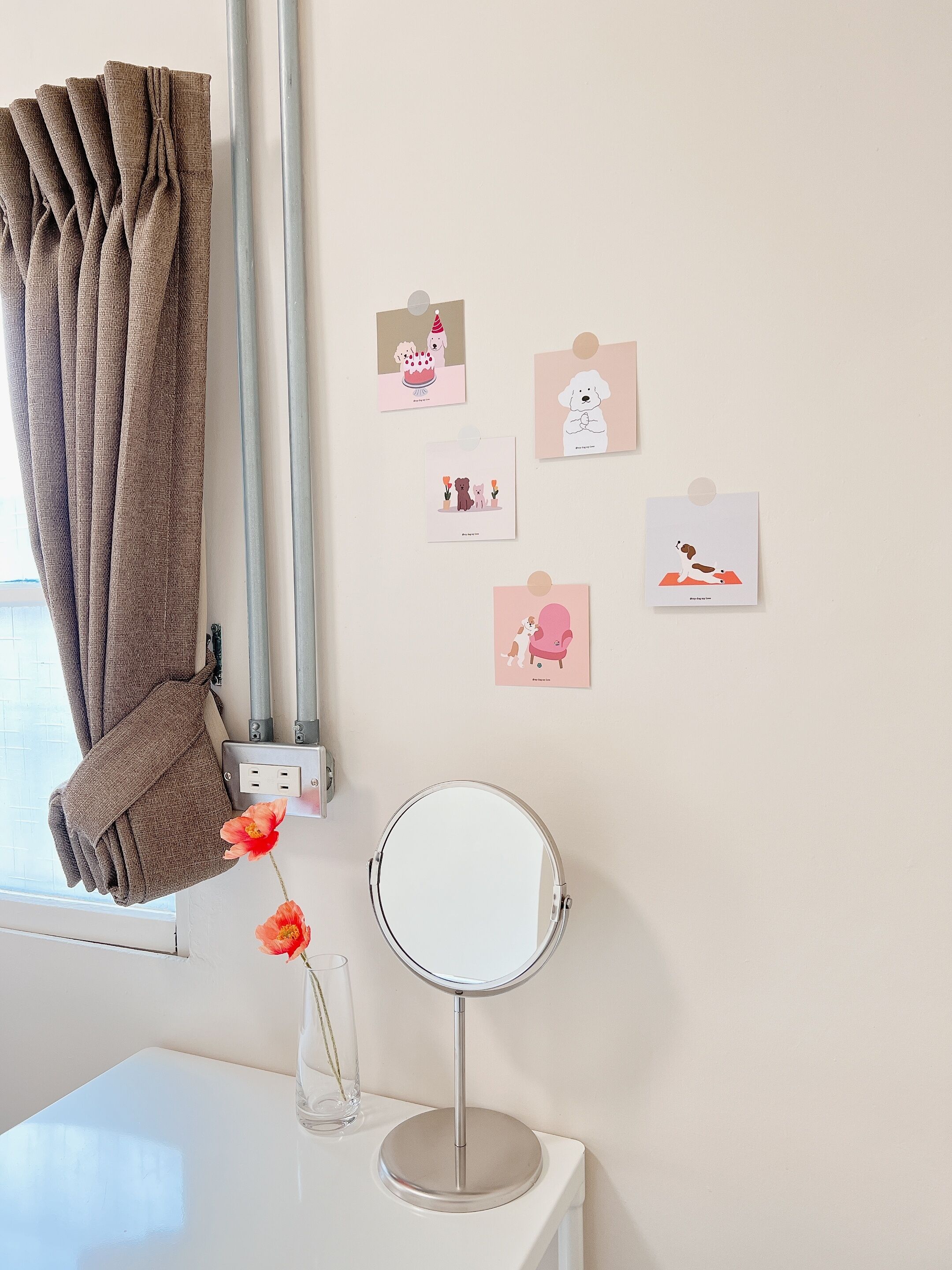 Una habitación con un escritorio blanco, un espejo redondo y una pared decorada con tarjetas de animales.