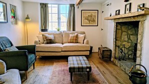 Un salon chaleureux avec un canapé, un fauteuil et une cheminée.