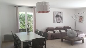 Un soggiorno moderno con zona pranzo, caratterizzato da un tavolo grande, sedie, un divano e un tavolino da caffè.