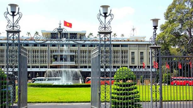 A building with a flag, a fountain, and a gated entrance. - Senses Central Hotel (Ho Chi Minh City)