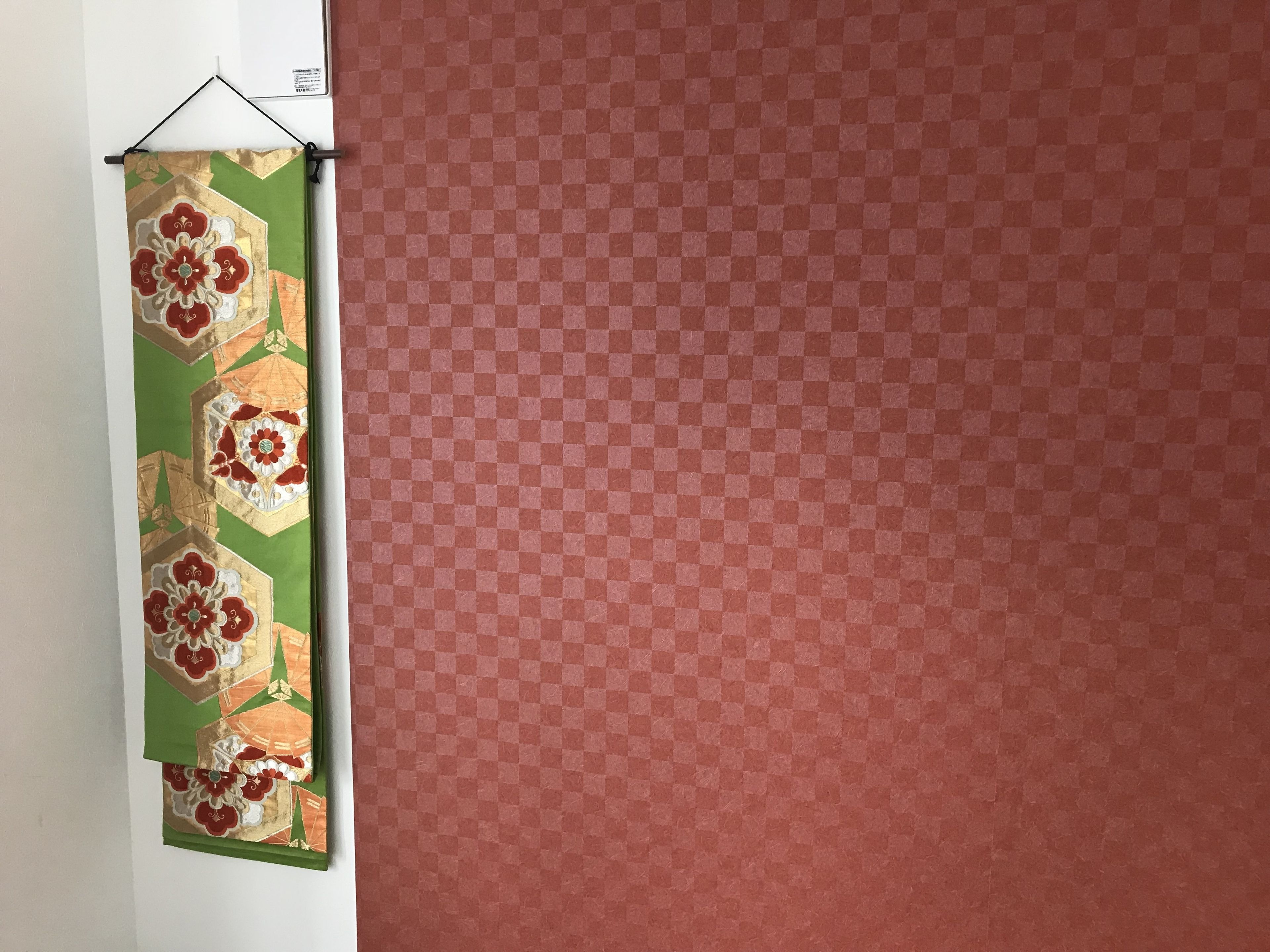 Een muur met behang en een decoratief object eraan.