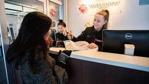 A reception desk at Hakuba Gateway Hotel with a sign above indicating the hotel name. - Hakuba Gateway Hotel (Hakuba)