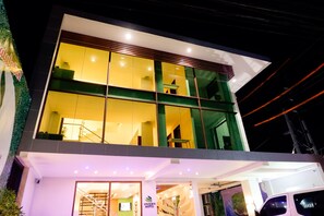 A modern hotel with a glass facade, a visible staircase, and a sign indicating the name 'VIVIEN'S HOTEL'. - Vivien's Hotel (Lapu-Lapu)