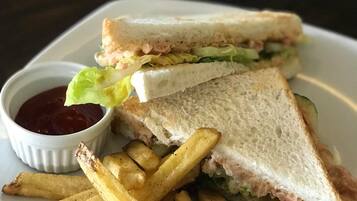 Um sanduíche com batatas fritas e ketchup no prato.
