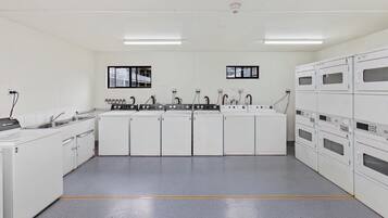A kitchen with white cabinets, numbered appliances, and a central island with a sink and stove.