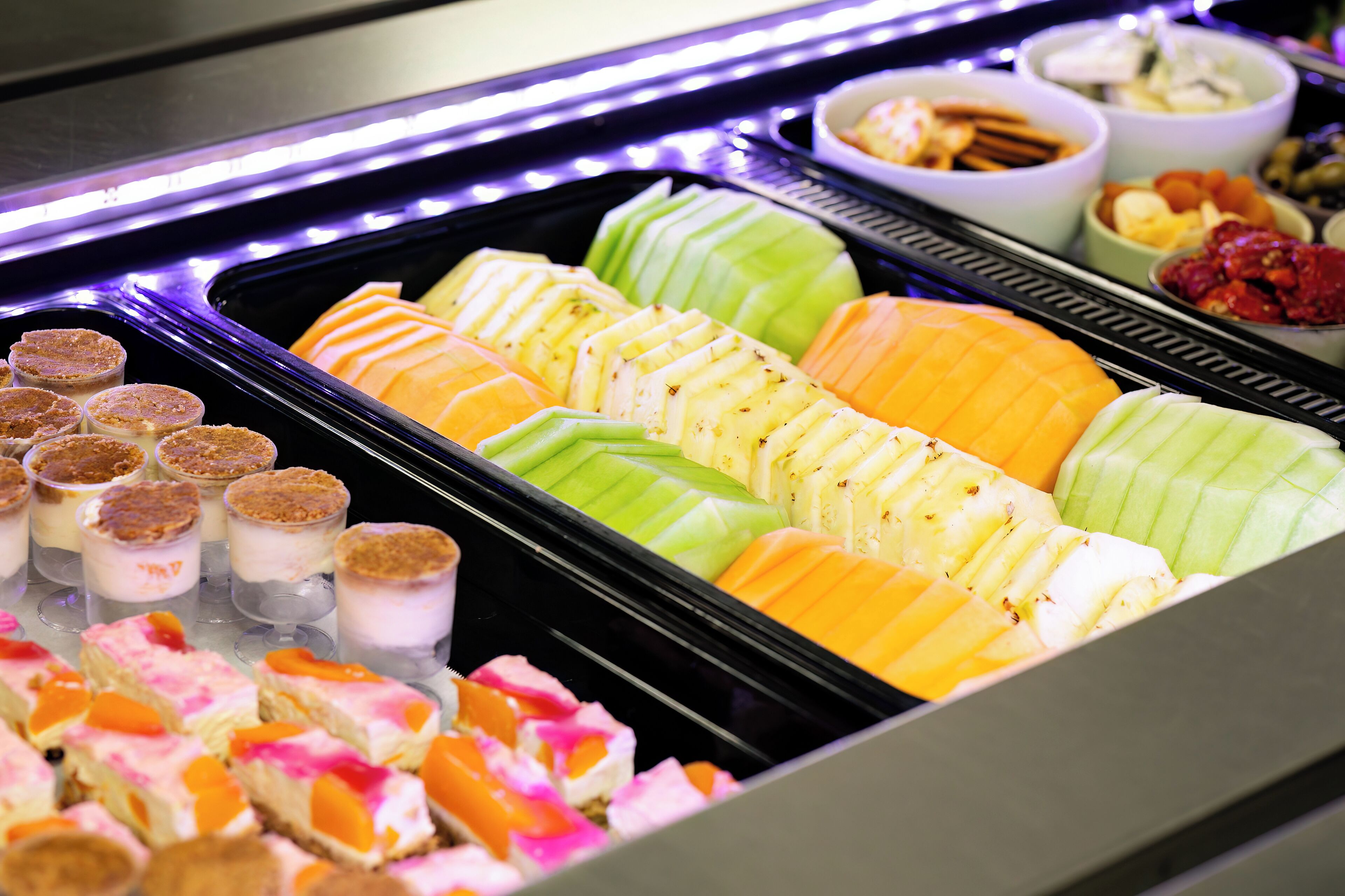 A buffet with various desserts and fruits.