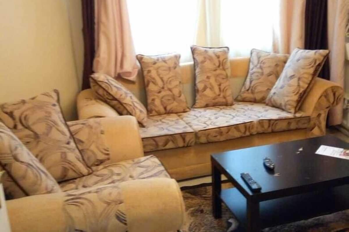 Una sala de estar con sofá, una mesita de centro y un tapete estampado.