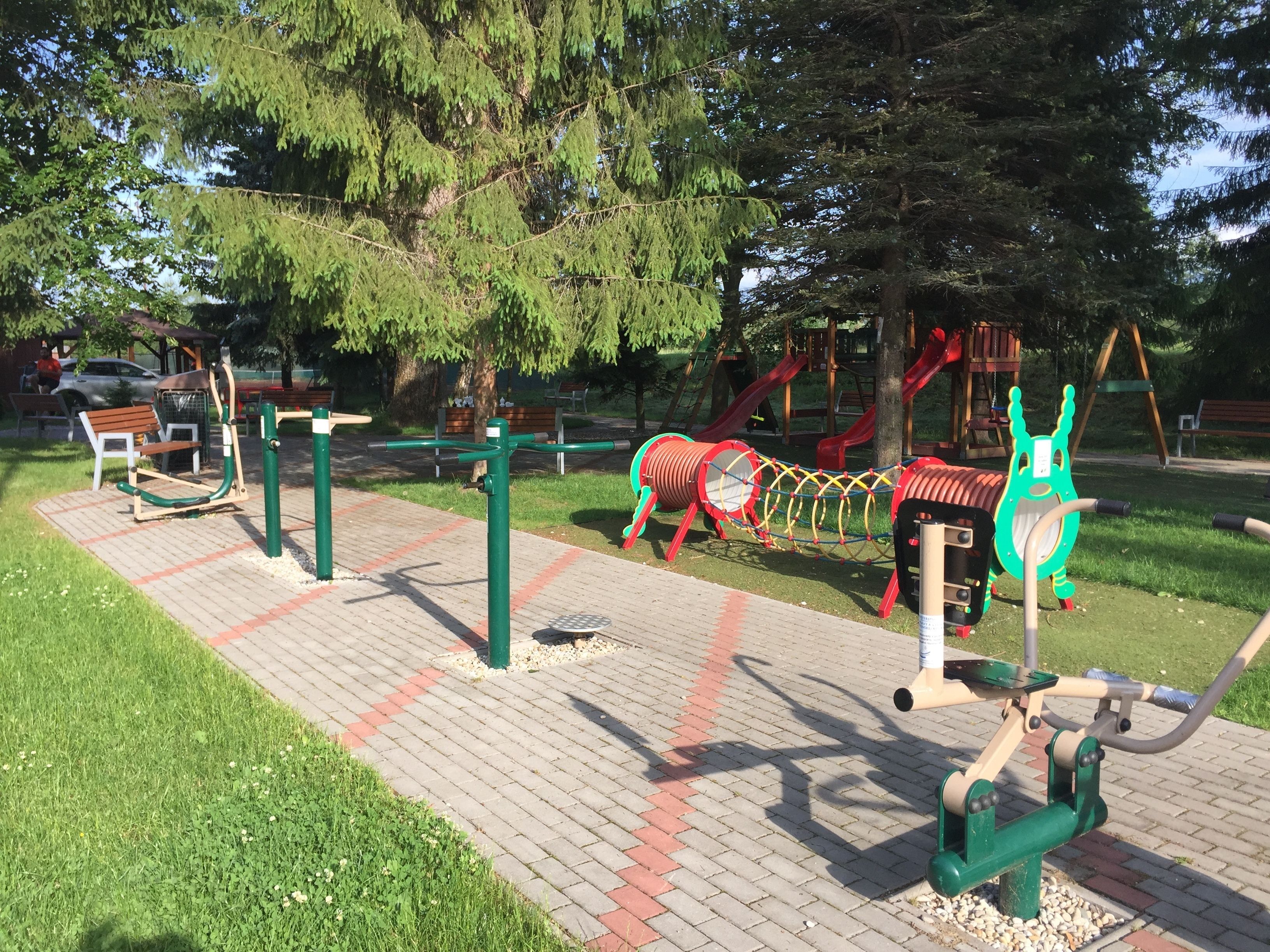Un parque infantil con equipamiento de ejercicio, un tobogán y columpios.