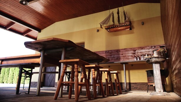 A wooden interior with a high ceiling, a ship model, and a bar area. - Apartmany u Slavky (Besenova)