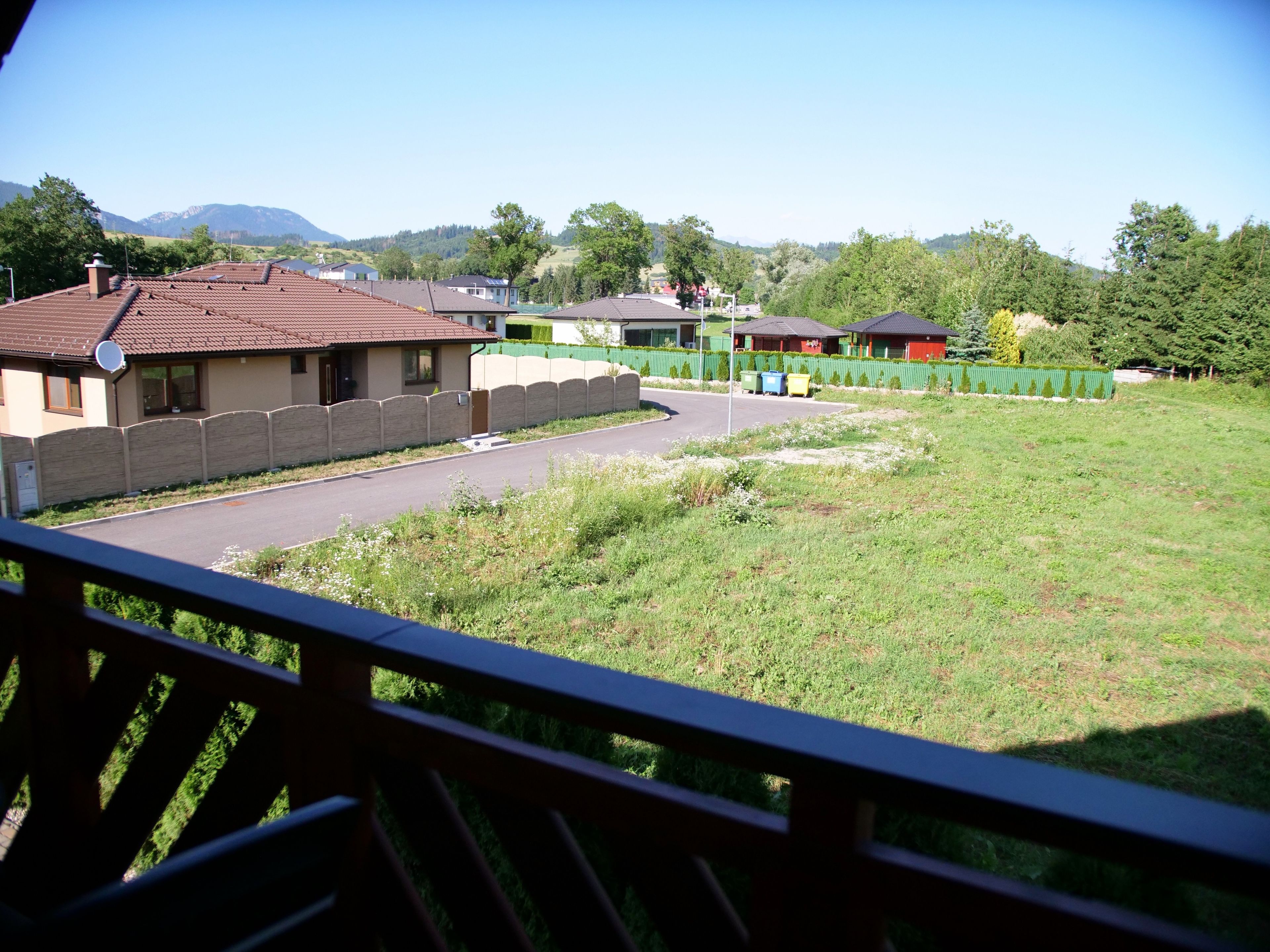 A residential area with houses, a road, and a green field.