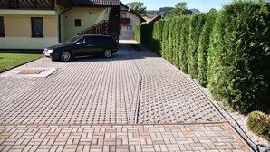 A residential driveway with a car parked on the left. - Apartmany u Slavky (Besenova)