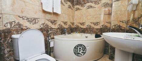 Ein Badezimmer mit Toilette, einer Badewanne mit einem Logo und einem Waschbecken.