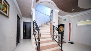 A staircase with a handrail, a door at the bottom, and a ceiling with a skylight. - Black Sea Star Batumi (Batumi)