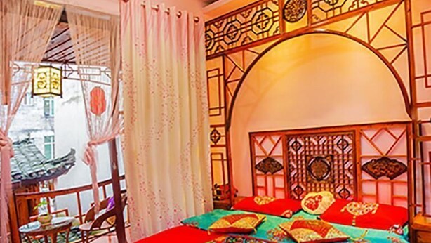 A traditional room with a bed, curtains, a table, and chairs.