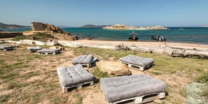 Udendørs siddepladser med udsigt over havet og det klippefyldte landskab.