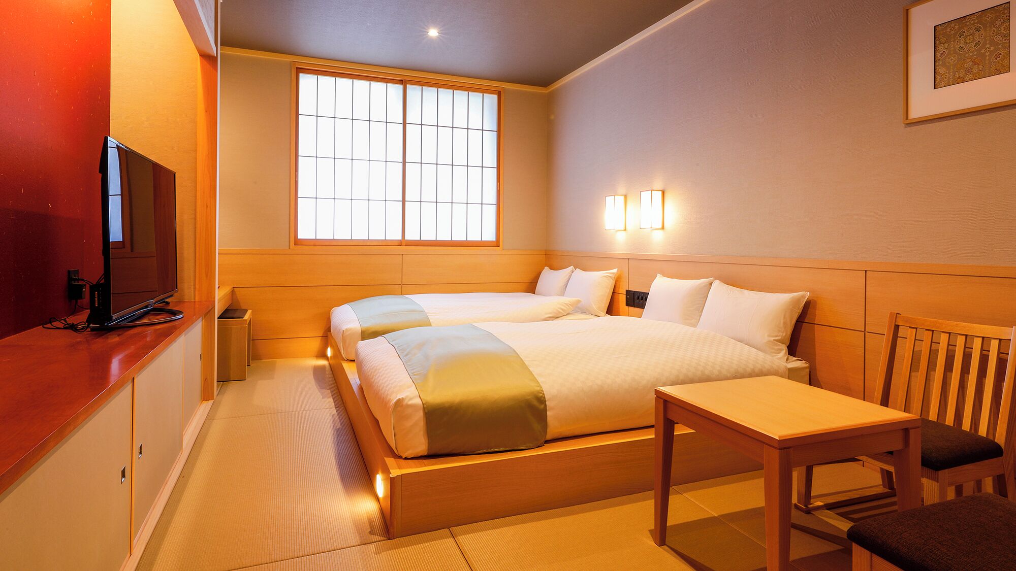A hotel room with a bed, bedside table, chair, TV, and a window.