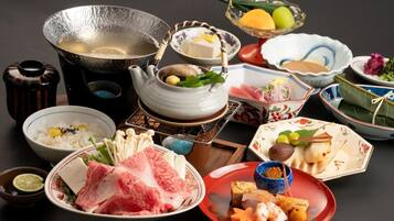 A variety of Japanese dishes and a teapot on a table.
