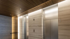 Un ascensore moderno con soffitto in legno e pareti metalliche.