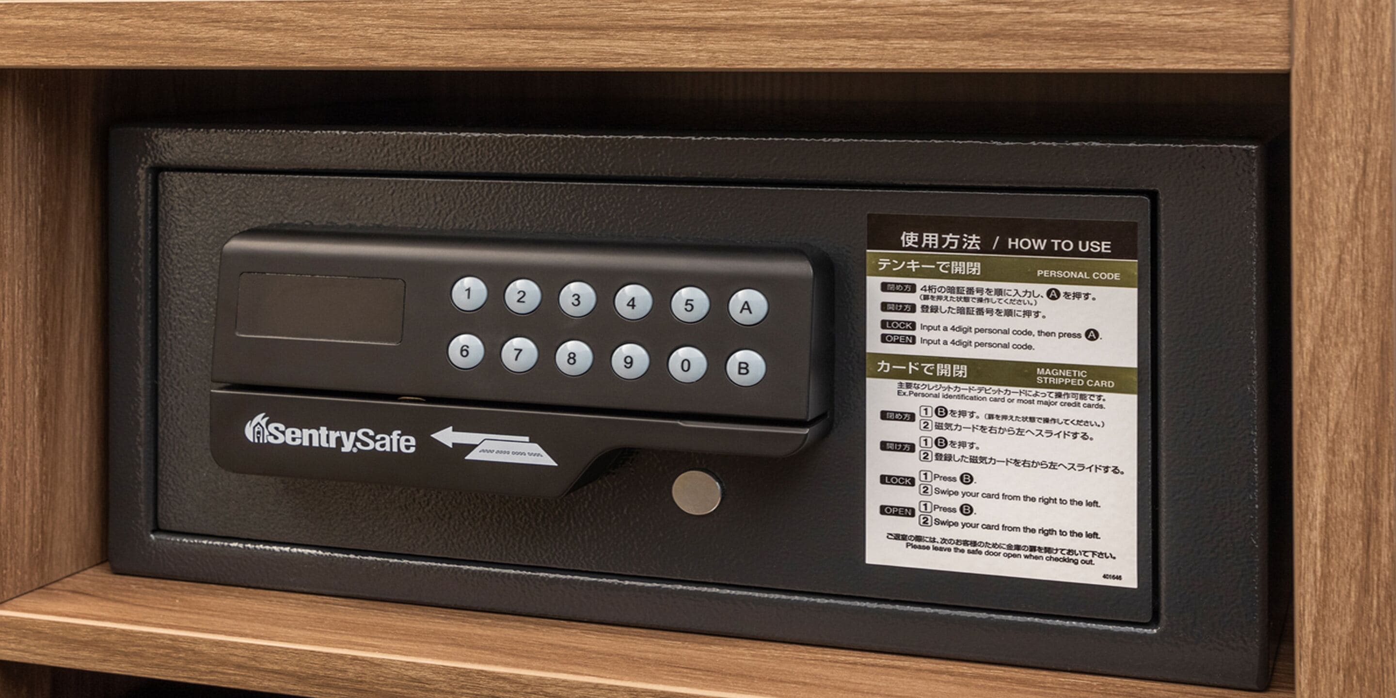 Een SentrySafe kluis met een keypad en instructies om te openen met een persoonlijke code of een magneetkaart.
