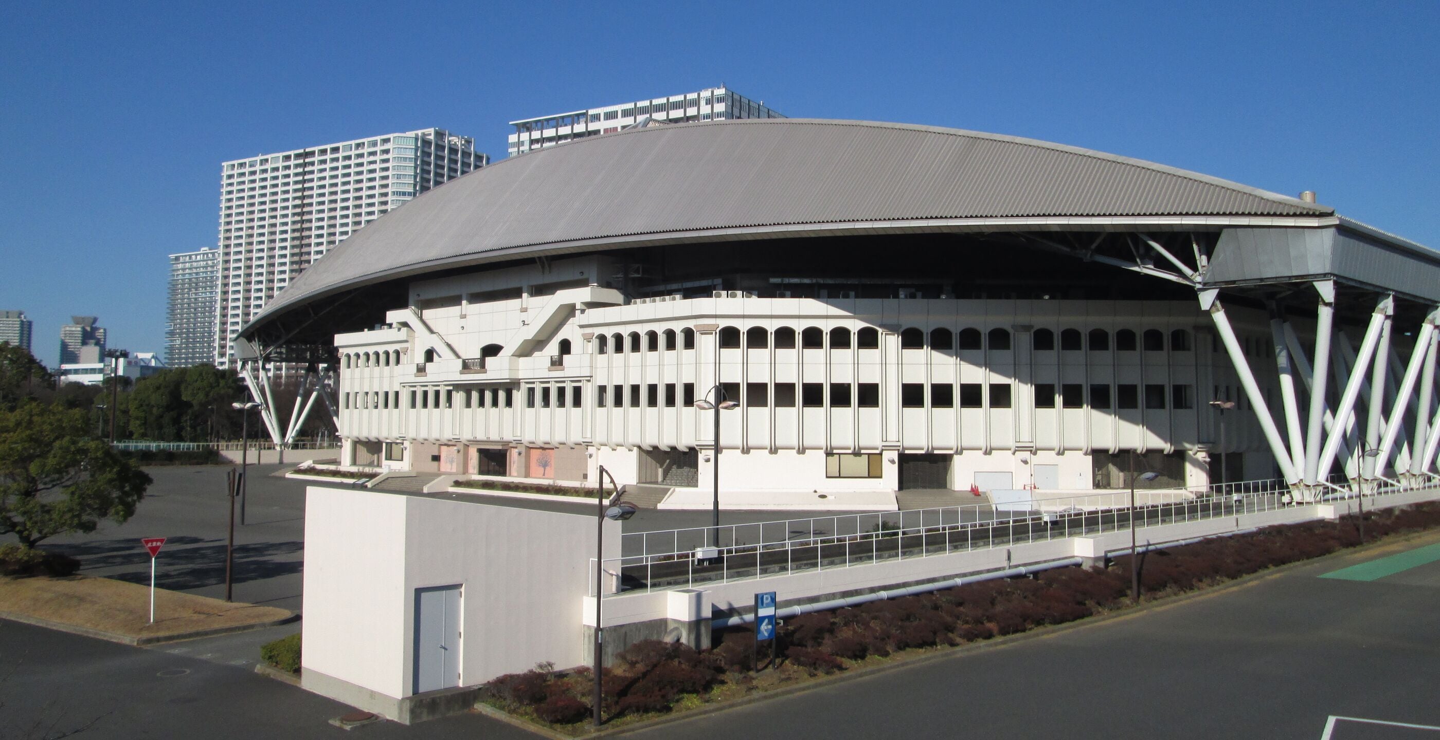 Ein großes, modernes Stadion mit einer gewölbten Dachkonstruktion und mehreren Sitzebenen.