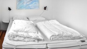A neatly made bed with white bedding and a mattress. - Stunning apartment in Vossestrand (Vossestrand)