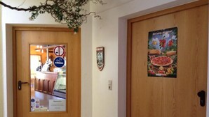A wooden door with a poster of a pizza and a no smoking sign. - Stadt Cafe Pension Grünstadt (Gruenstadt)