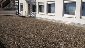 A building with a gravel driveway and a fire escape. - Stadt Cafe Pension Grünstadt (Gruenstadt)