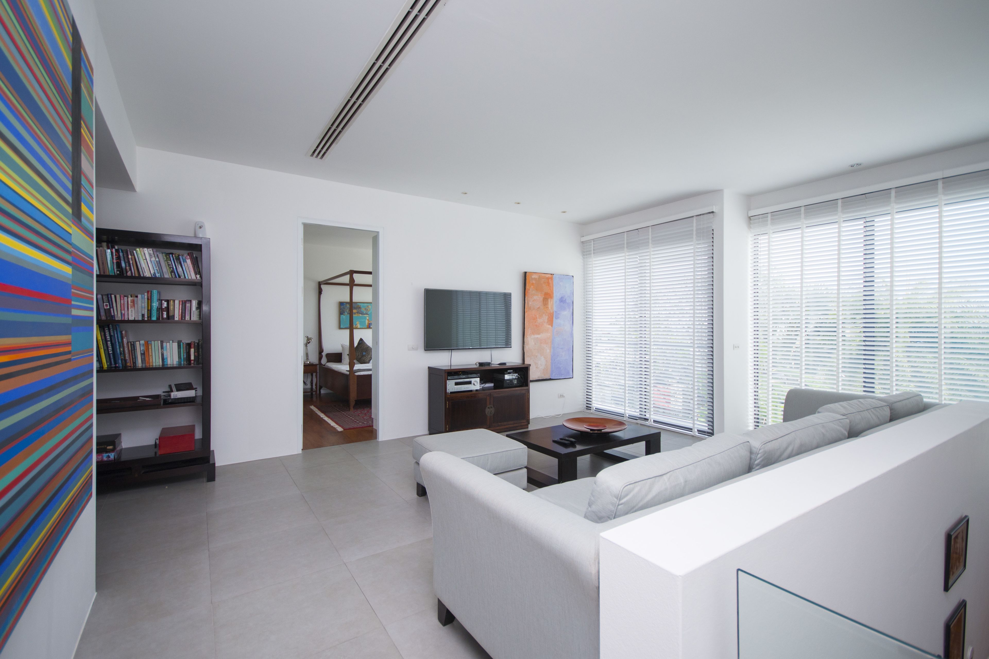 Una sala de estar moderna con sofá, mesa de centro y estantería.