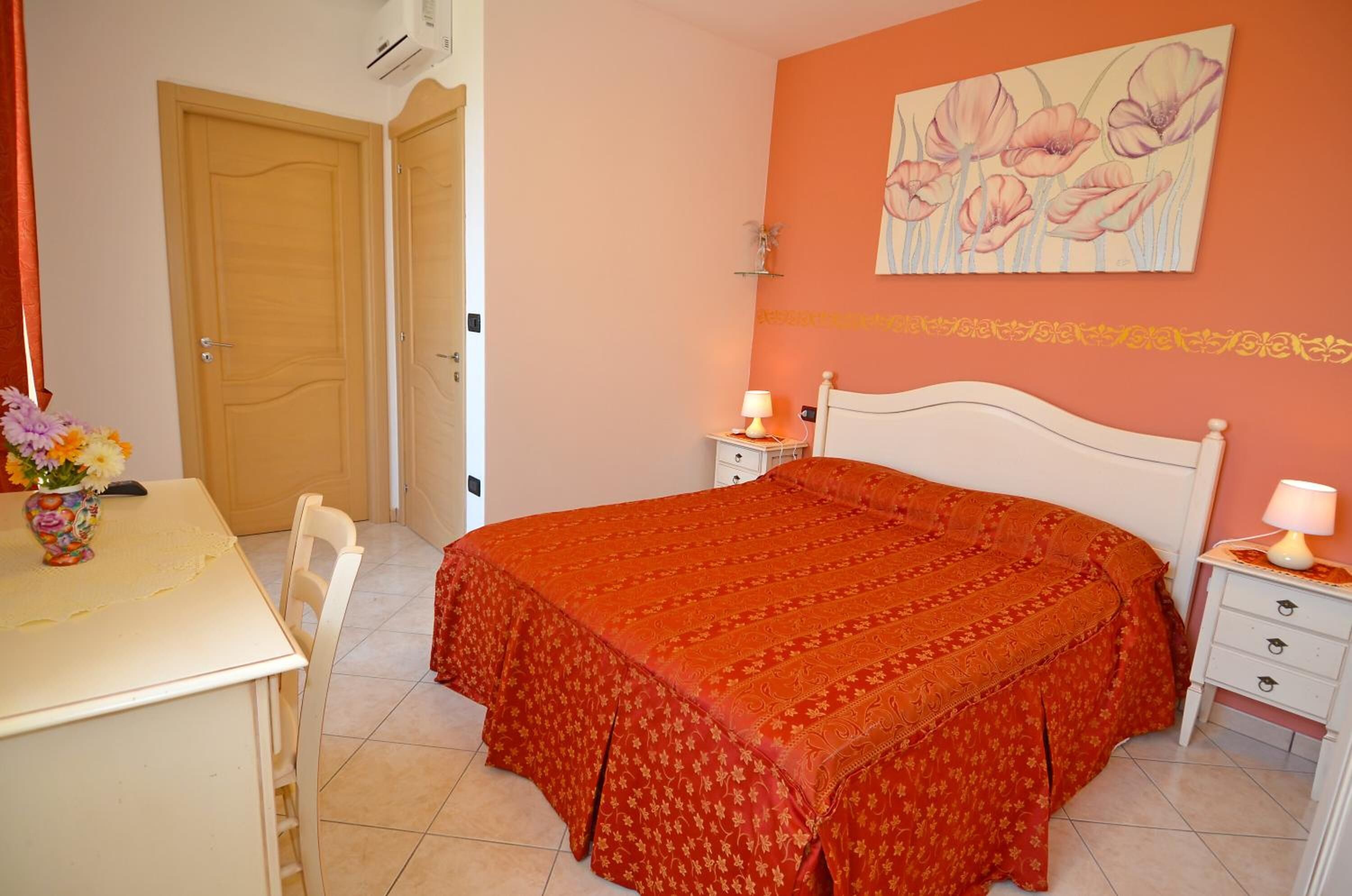 Ein Schlafzimmer mit Bett, Nachttisch und einem Bild an der Wand.