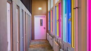 A hallway with a wooden floor and doors on both sides. - BoxHotel Hannover (Hannover)
