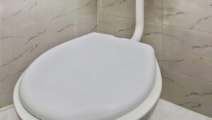 A white toilet with a marble-patterned wall and floor. - OYO 24812 Kashmir Houseboats By Ats-rooms (Srinagar)