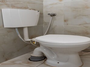 Toilet met een witte tank en een apart bidet.