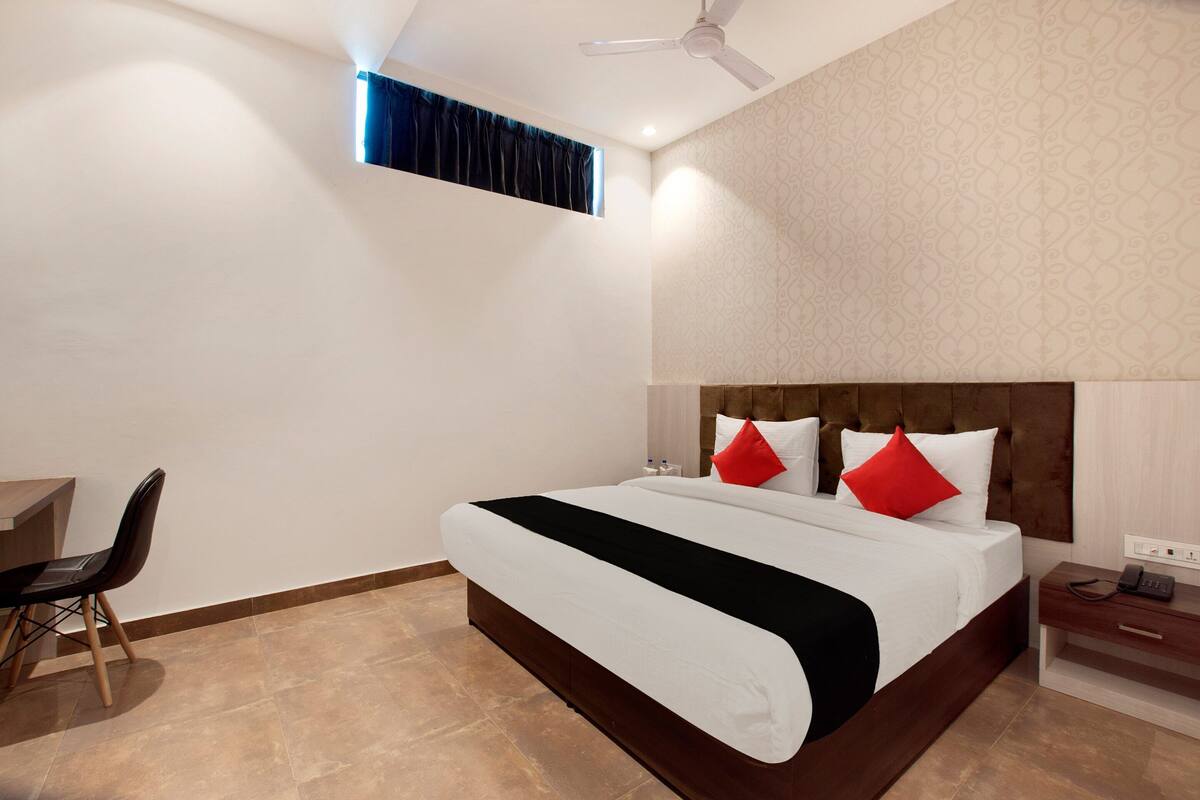Ein modernes Hotelzimmer mit einem großen Bett, einem Schreibtisch und einem Sessel.