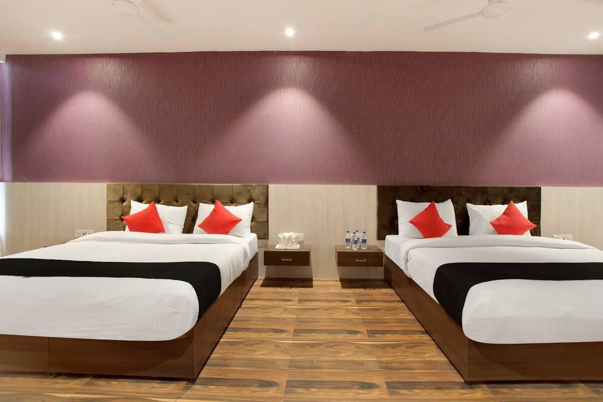 Ein Hotelzimmer mit zwei Betten, Holzboden und modernem Design.