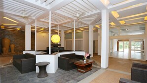 A spacious lobby with modern furniture, a reception desk, and a large decorative light fixture. - Capital O 29855 Island Inn (Kanayannur)