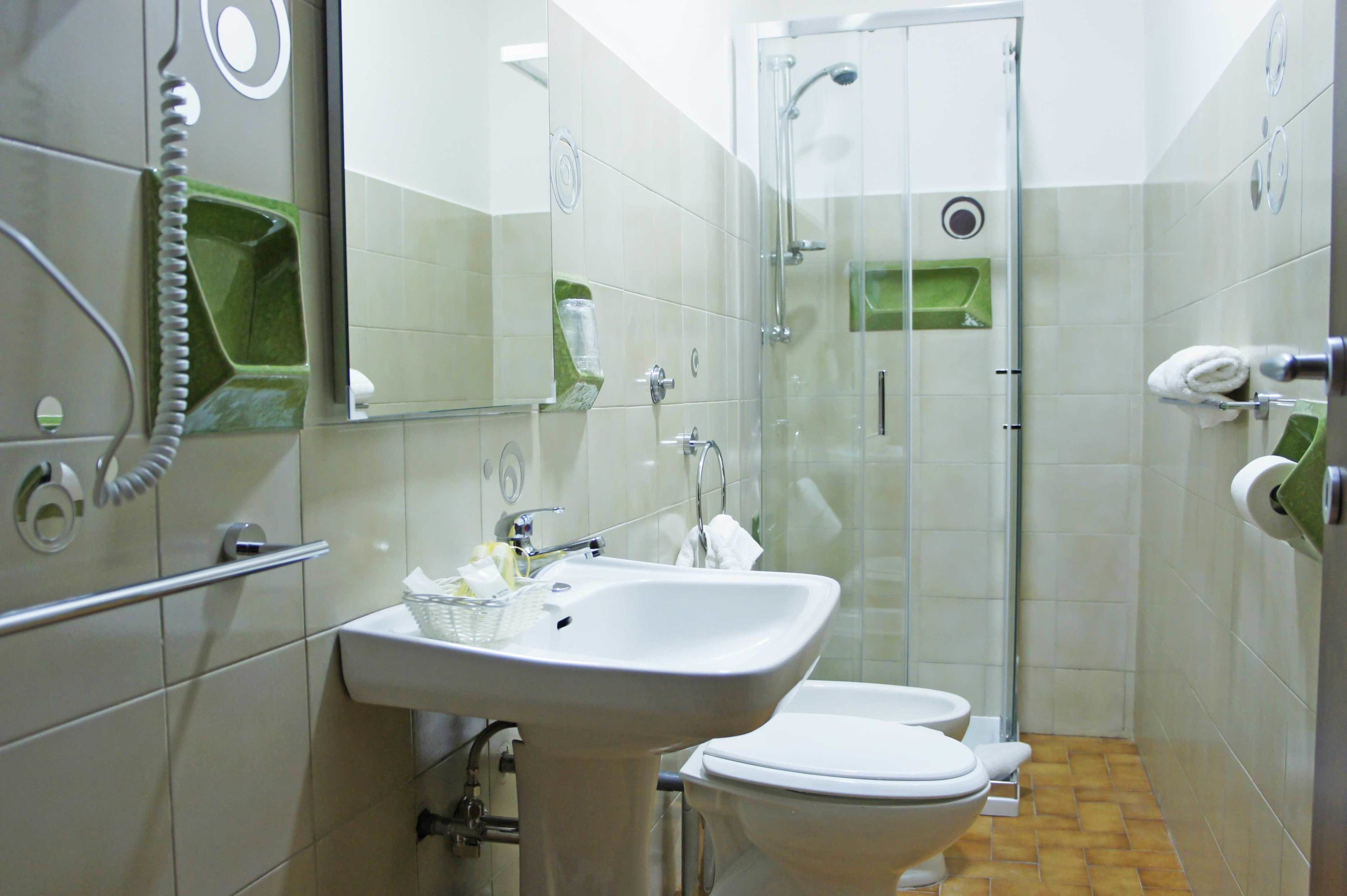 A bathroom with a sink, toilet, and shower.