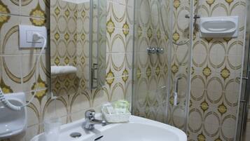 A bathroom with a sink, mirror, and shower.