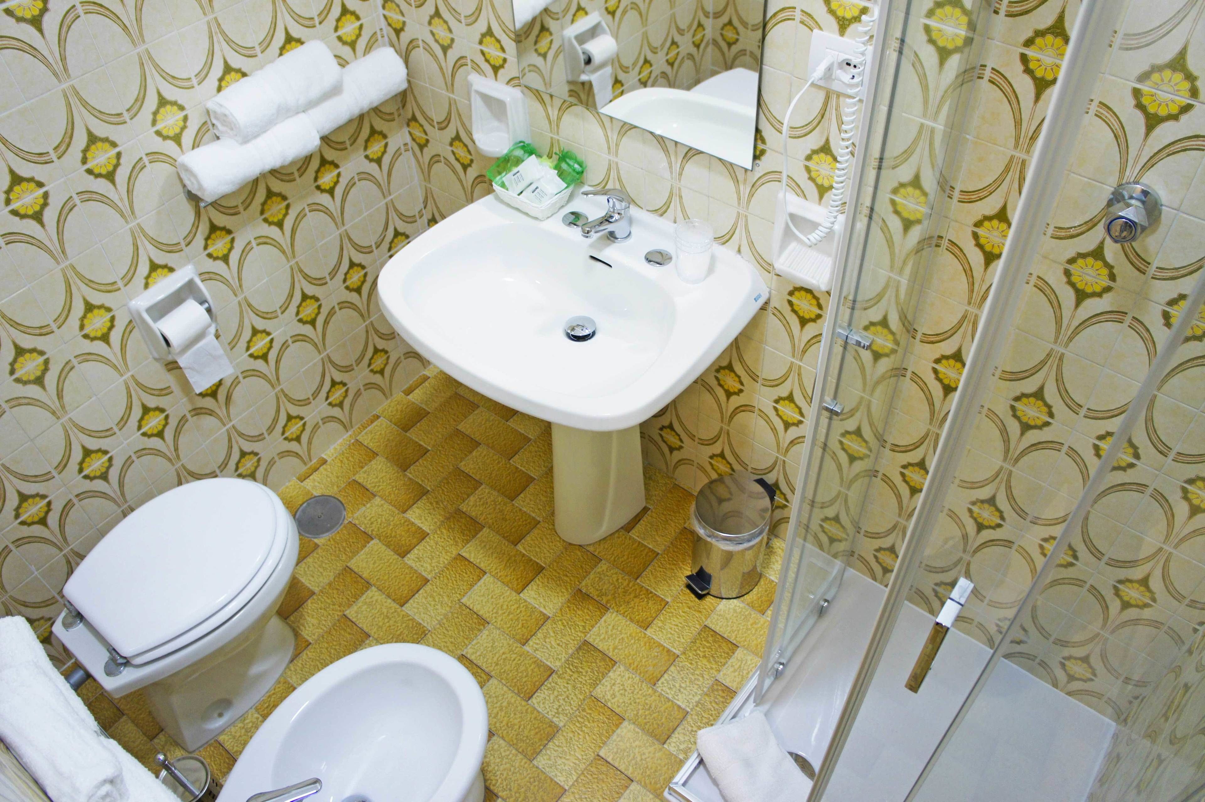 Un baño con inodoro, lavamanos y bidé.