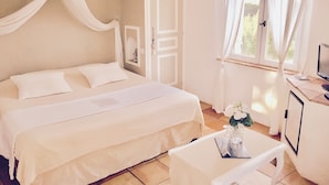 Een slaapkamer met een bed, nachtkastje, stoel en televisie.