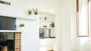 A modern living room with a fireplace, built-in shelves, and a television. - Breathtaking view from a charming apartament (Menaggio)