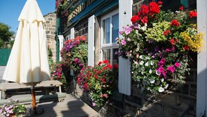 A building with a stone facade, white shutters, and a sign that reads "HILARY ARMS." - Busfeild Arms (Keighley)
