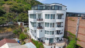 Un edificio de varios pisos con balcones, ventanas amplias y techo plano.
