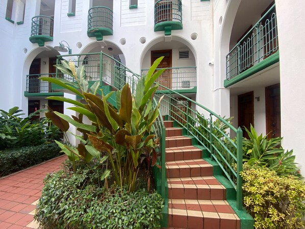 A multi-story building with green railings and a tiled staircase. - Ocho Rios Sandcastles King Suite with Balcony & Beach Access – Ideal for Couples (Ocho Rios)