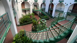 A multi-level courtyard with green railings and tiled floors, featuring multiple balconies and staircases. - Ocho Rios Sandcastles King Suite with Balcony & Beach Access – Ideal for Couples (Ocho Rios)