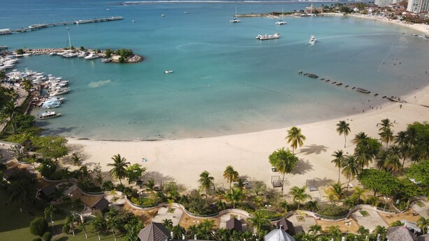 A coastal resort with a marina, sandy beach, and palm trees. - Ocho Rios Sandcastles King Suite with Balcony & Beach Access – Ideal for Couples (Ocho Rios)