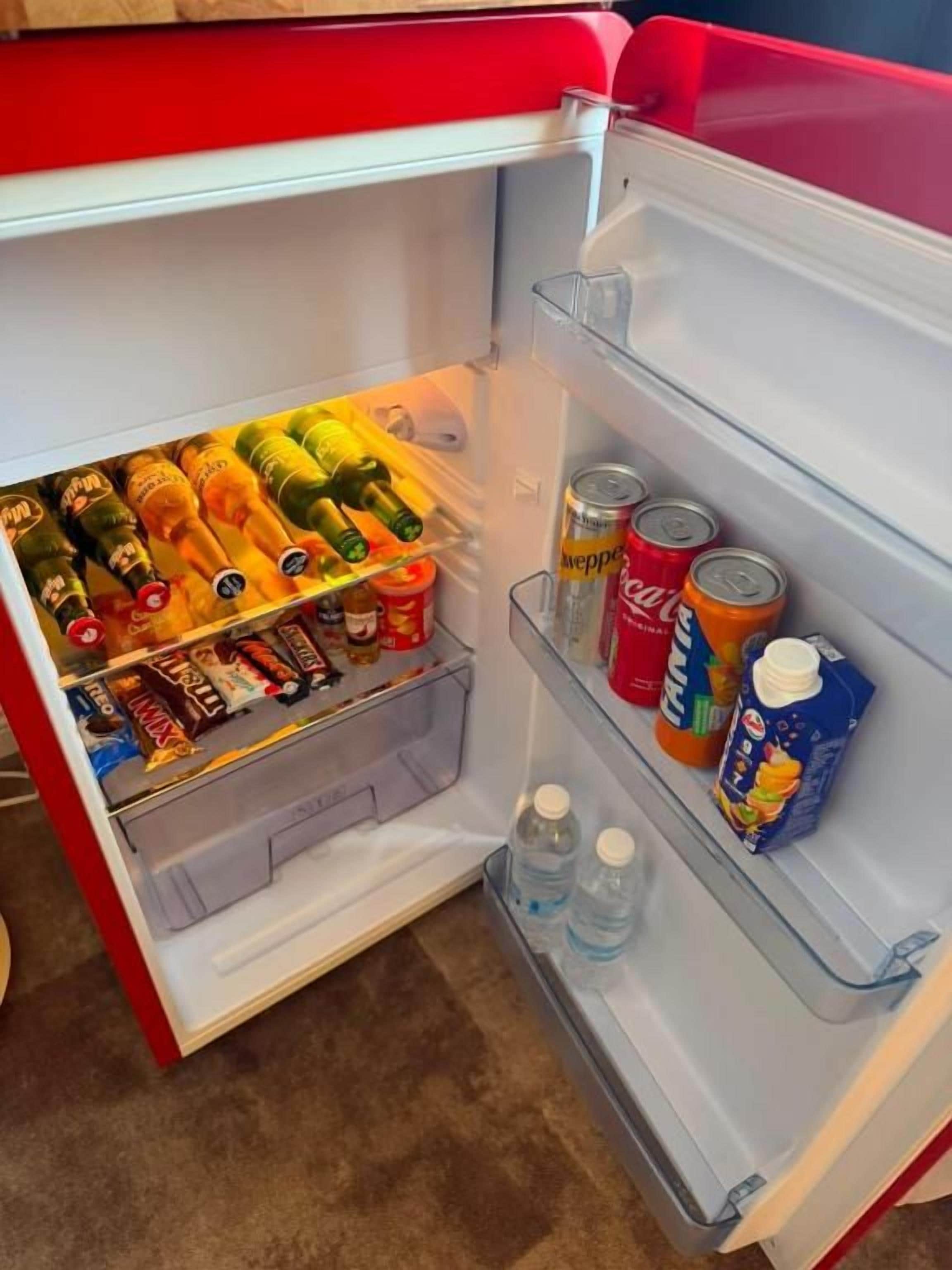 Un refrigerador abierto con diversos alimentos y bebidas.